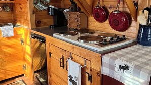 Une cuisine compacte dotée de meubles en bois, d’un four à micro-ondes, d’un grille-pain et d’une bouilloire.