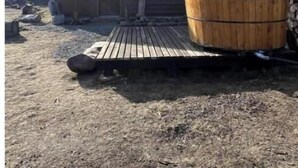 Un chalet rustique doté d’une terrasse en bois et d’un bain à remous.