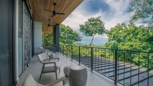 A balcony with a view of lush greenery and a clear sky. - Family Getaway w/ Ocean & Valley Views in Guiones (Nosara)