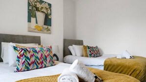 Een hotelkamer met twee bedden, elk met een verschillend beddekleed.