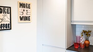 Eine Küche mit weißen Schränken, einer Arbeitsplatte mit Dekoration und zwei Wandbildern.