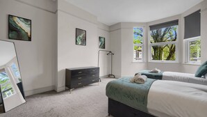 A bedroom with a bed, a dresser, and two windows. - Free Parking Fast Wifi 2 Min to Cardiff City (Cardiff)