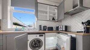 A modern kitchen with built-in appliances, a window, and a view of the outside. - Free Parking Fast Wifi 2 Min to Cardiff City (Cardiff)