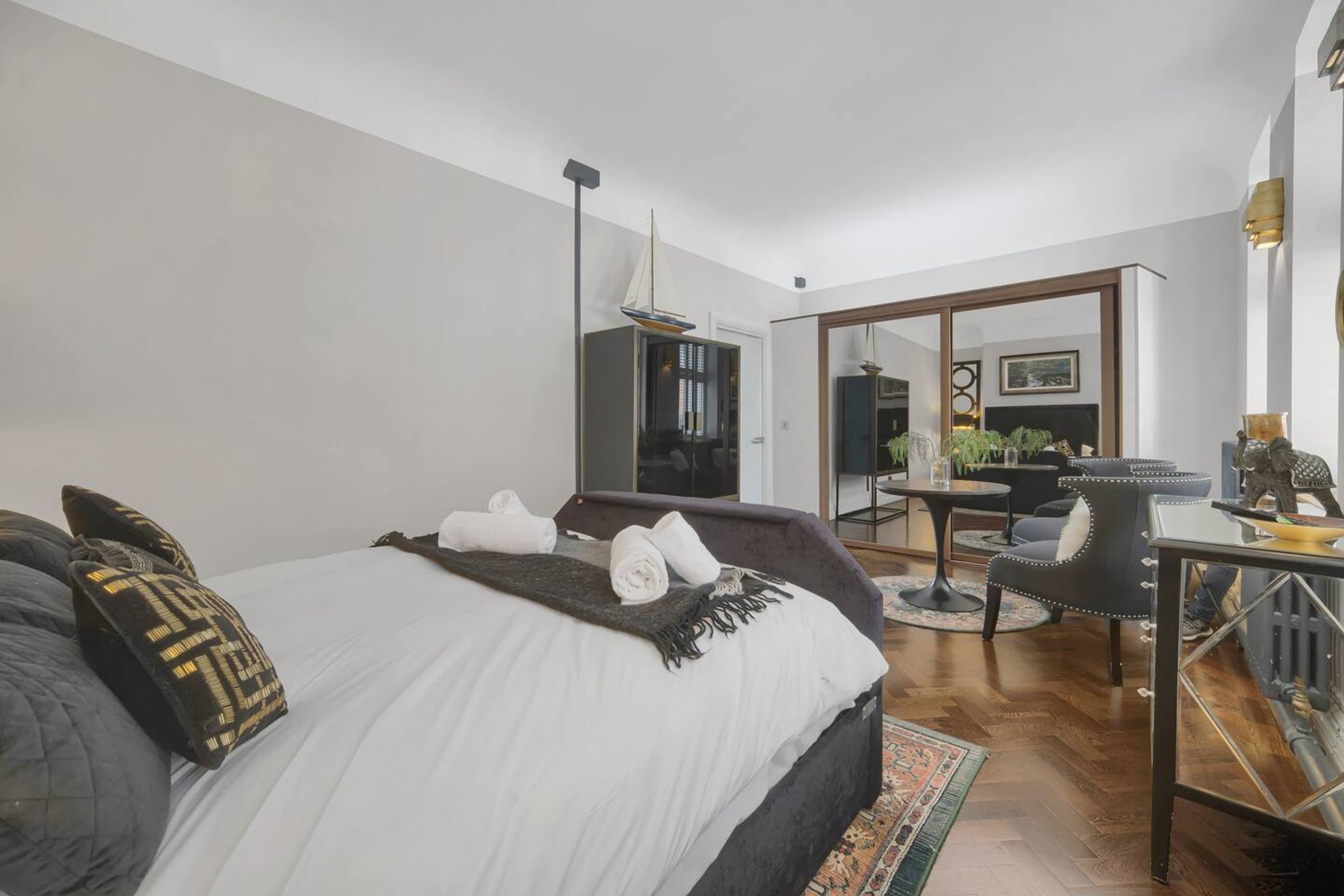 Una habitación de hotel moderna con una cama grande, un escritorio y un rincón de comedor.