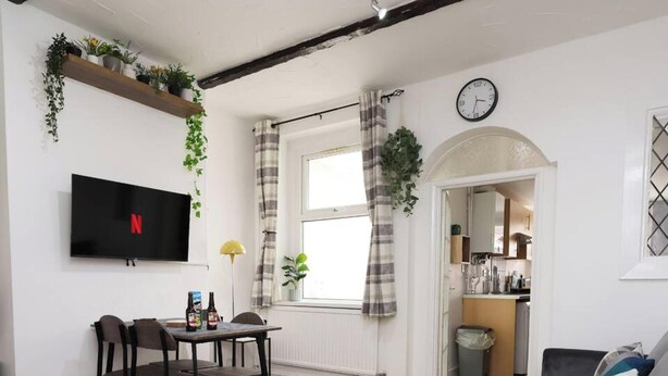 A modern, spacious living area with a TV, dining table, and seating. It features a 3-bedroom layout, high-speed WiFi, and is close to the city center. - Central Escape Central Cardiff Free Parking (Cardiff)