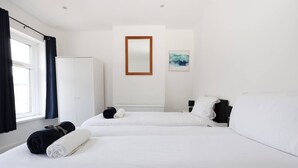 A hotel room with two beds, a wardrobe, a mirror, and a painting on the wall. - Central Escape Central Cardiff Free Parking (Cardiff)