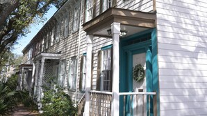 A white building with a porch, a large tree, and a pathway. - The Jungle Nook: Themed,Steps to Forsyth,King Bed,Grill,Games,Picnic Basket (Savannah)