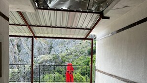 Un balcón amplio con vistas a terreno rocoso y vegetación.