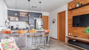 Eine moderne Küche mit Kochinsel, Barhocker und Essbereich.