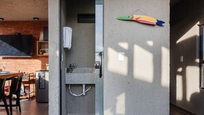 Eine moderne Küche mit einem Holztisch, einem eingebauten Fernseher und einem Kühlschrank.