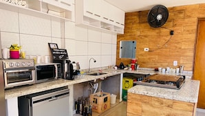 A modern kitchen with a built-in oven, microwave, coffee maker, and a gas stove.