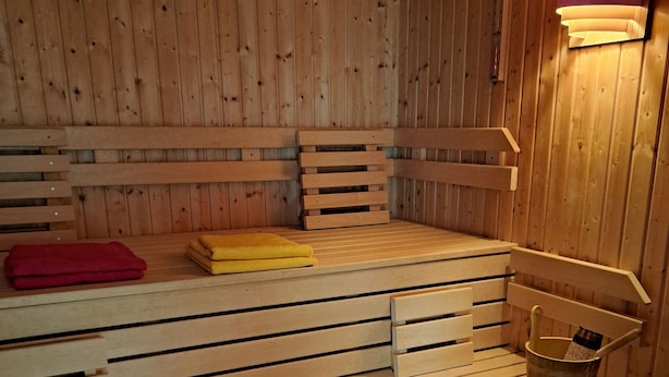 A wooden sauna with benches and a small table.