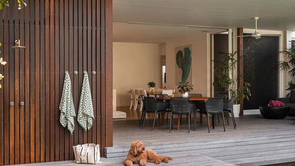 A modern dining area with a wooden partition, a dog, and a dining table with chairs.