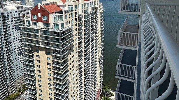 Un edificio de gran altura con varios balcones que dan a una masa de agua.