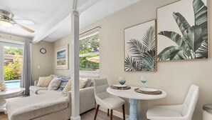 A living room with a sofa, two chairs, a coffee table, and a dining table with a clock and framed artwork on the wall. - Discover Your Ideal Retreat in Fort Lauderdale (Fort Lauderdale)