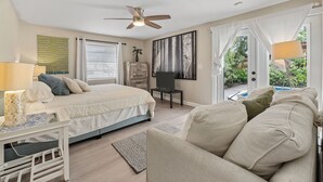 A bedroom with a bed, a chair, a desk, and a window with a view of greenery. - Discover Your Ideal Retreat in Fort Lauderdale (Fort Lauderdale)