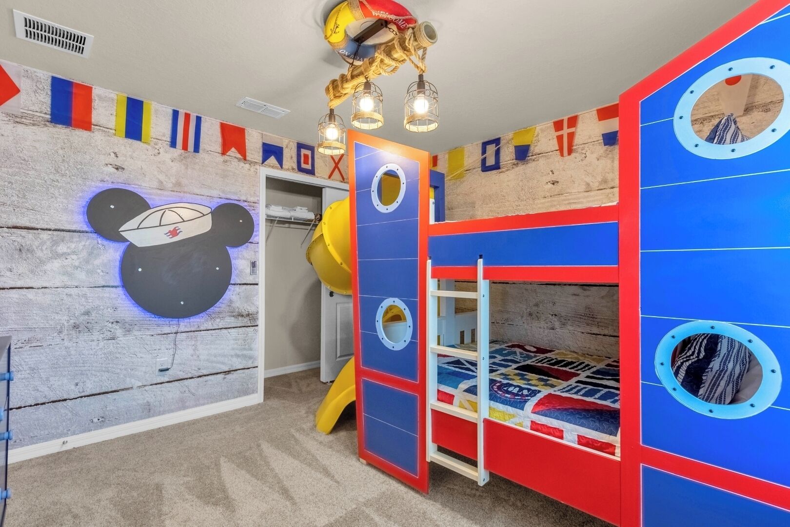 Une salle de jeux pour enfants avec un toboggan, des lits superposés et une décoration murale sur le thème des ours.