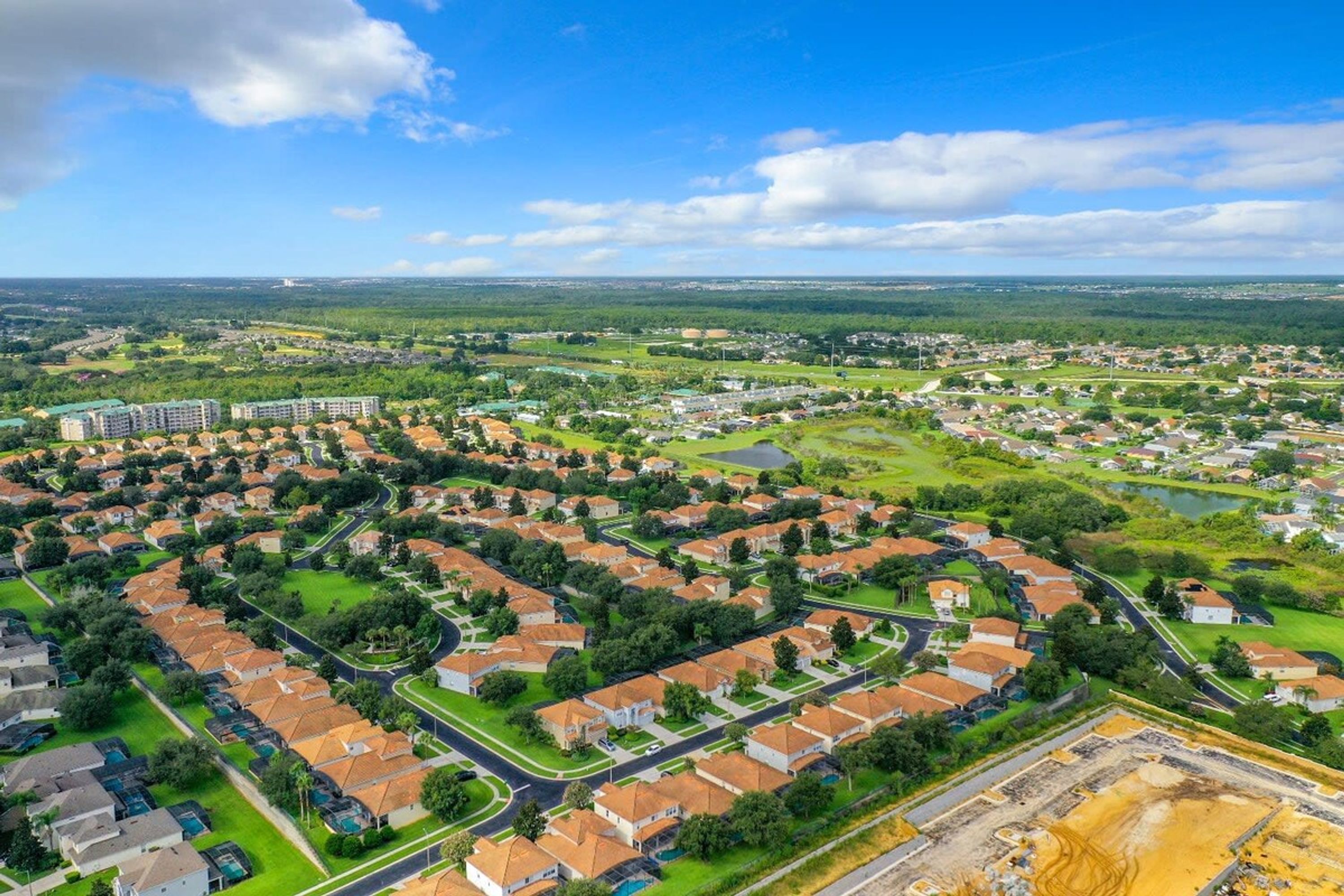 Zona residencial con casas unifamiliares y edificios de apartamentos, calles y áreas verdes.