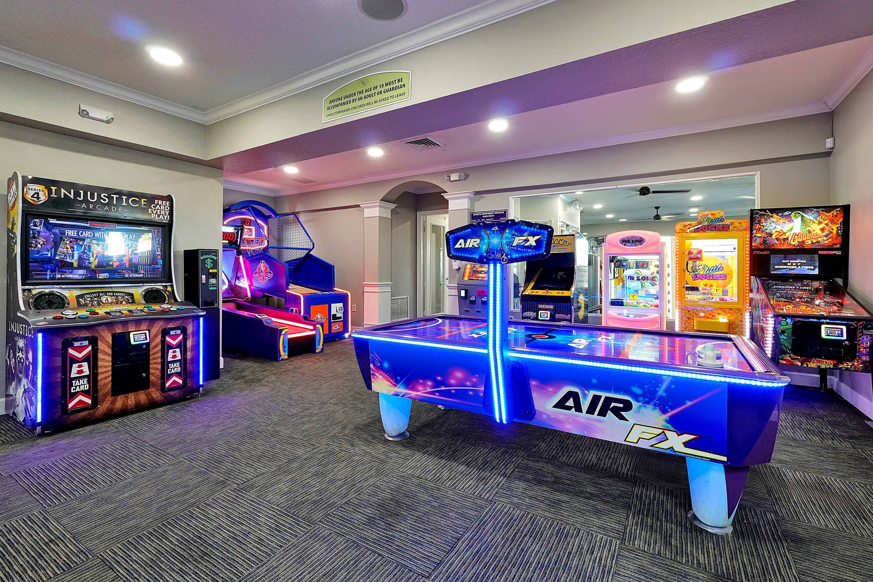 An indoor arcade with various gaming machines, including a pool table and multiple arcade games.