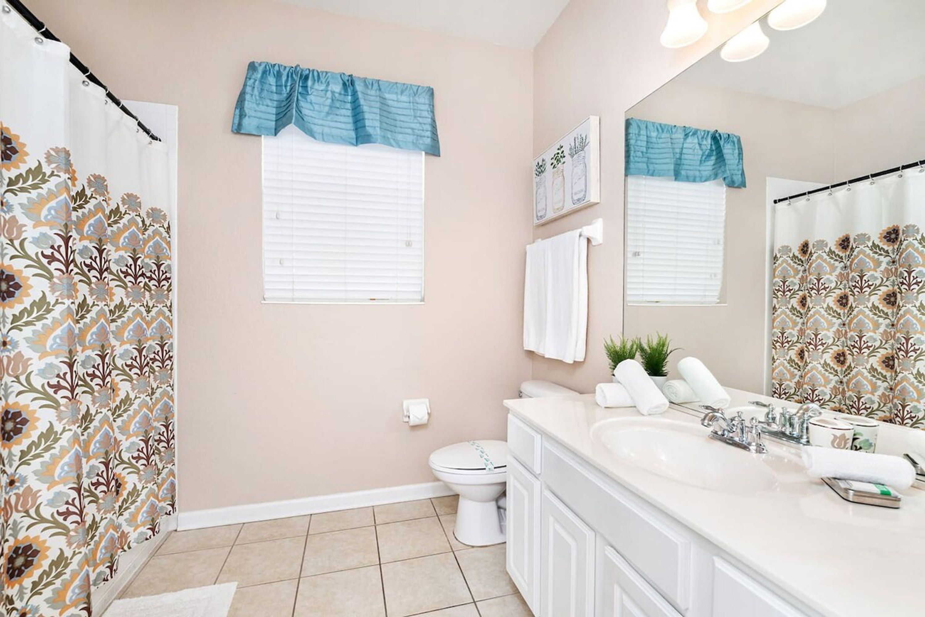 Une salle de bain équipée de toilettes, d’un lavabo et d’un rideau de douche.