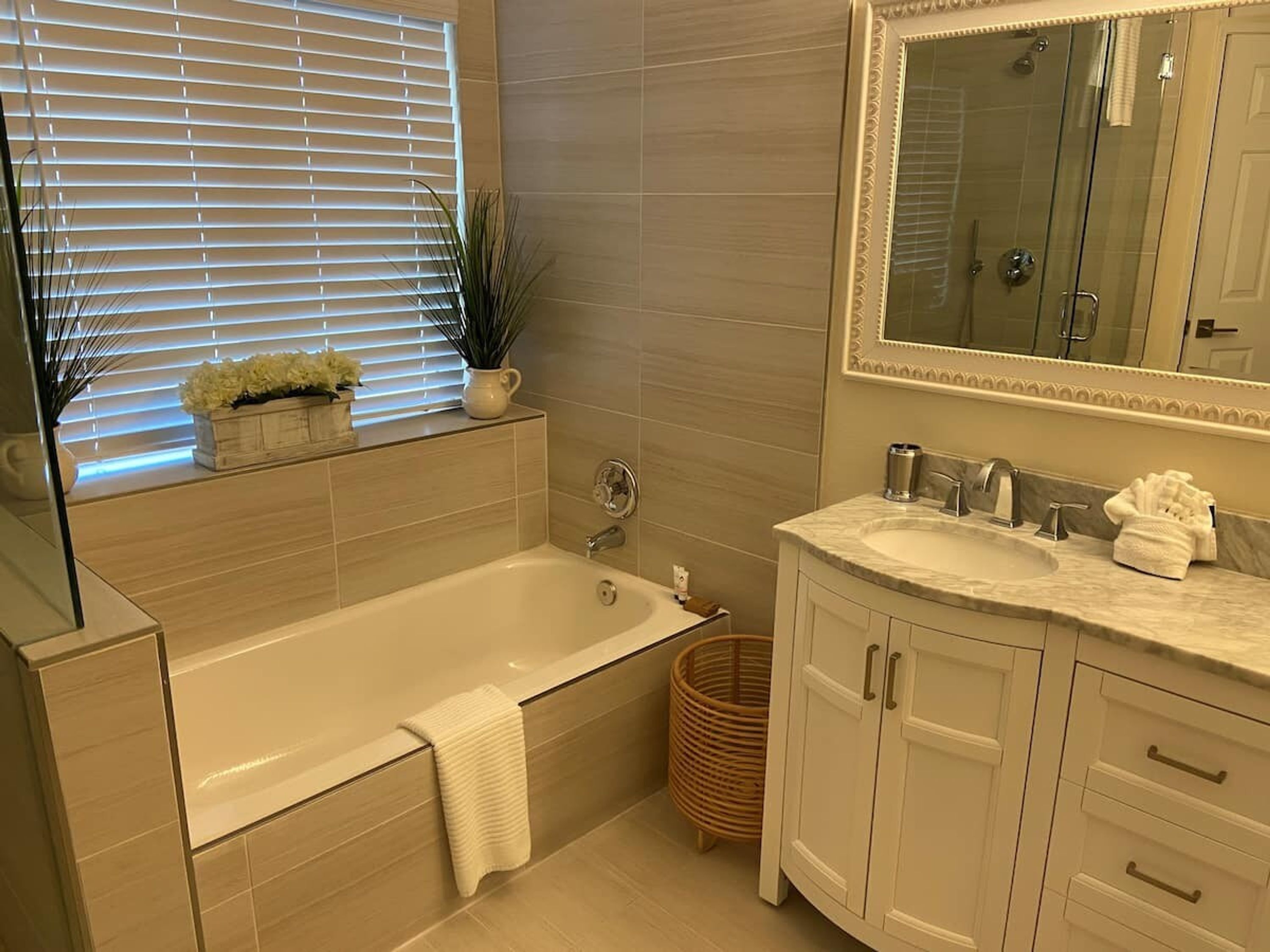 Een moderne badkamer met een bad, een wastafel en een spiegel.
