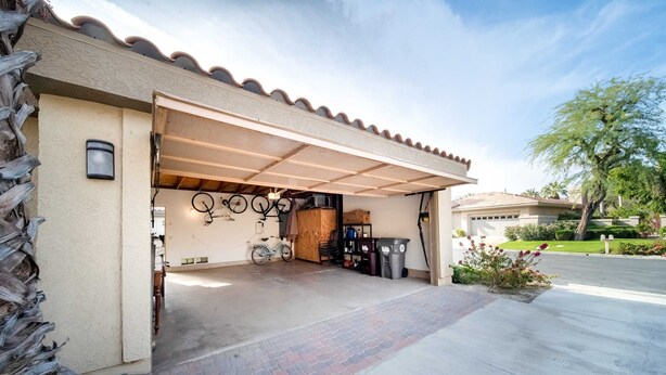 A garage with a tiled floor, a bicycle, and a trash bin. - Casa de Vista Fairway View w Pool Spa PGA West (La Quinta)