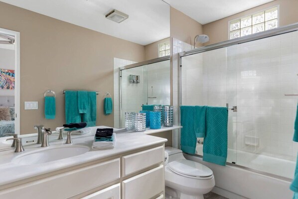 Une salle de bain moderne avec une douche à parois de verre, un lavabo blanc et des toilettes.