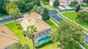A residential area with houses, a swimming pool, and a road. - Ultimate Adventure Villa Top Rated 5 Star Disney More (Kissimmee)