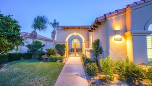 A residential building with a gated entrance, a well-maintained lawn, and a pathway leading to the door. - Casa Santiago Private Pool Firepit Golf View (La Quinta)