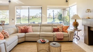 A living room with a beige sectional sofa, two round coffee tables, and a fireplace. - Casa Santiago Private Pool Firepit Golf View (La Quinta)