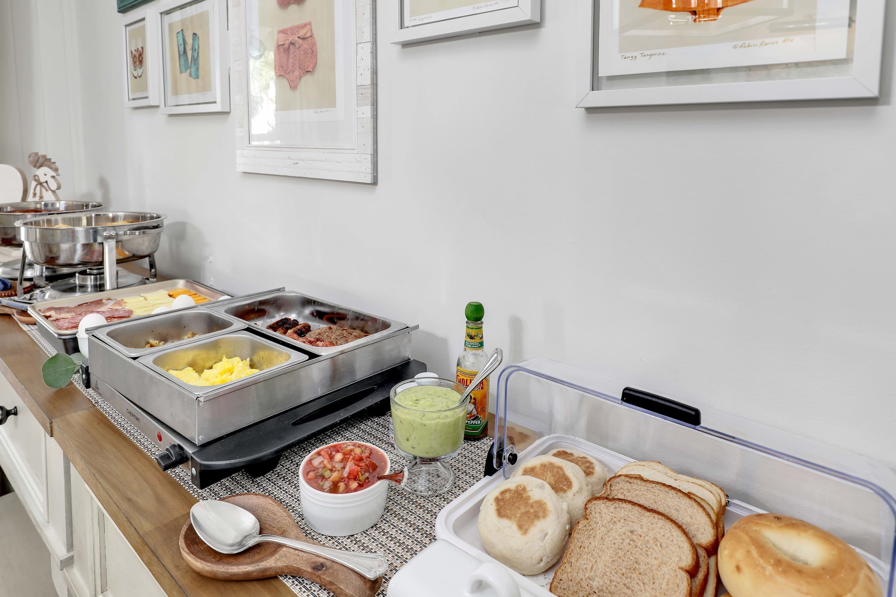 Un bufé con diversas opciones de comida, como carnes, vegetales y panes.