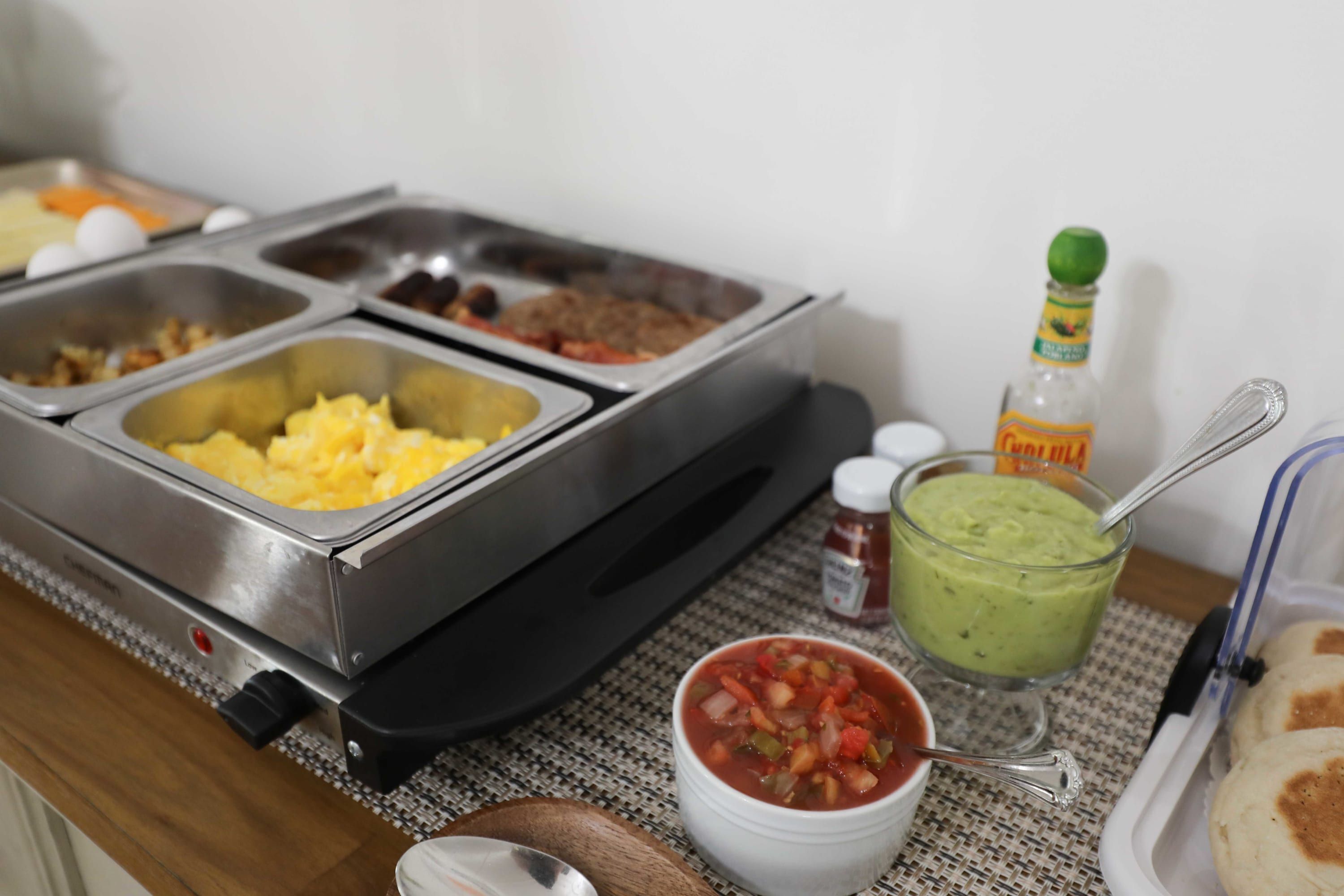 A buffet setup with various food items and condiments.