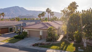 A residential area with houses featuring tiled roofs, well-maintained lawns, and palm trees. - 5 Star Rating Oasis Golf Pool Spa 3bed Pga West (La Quinta)