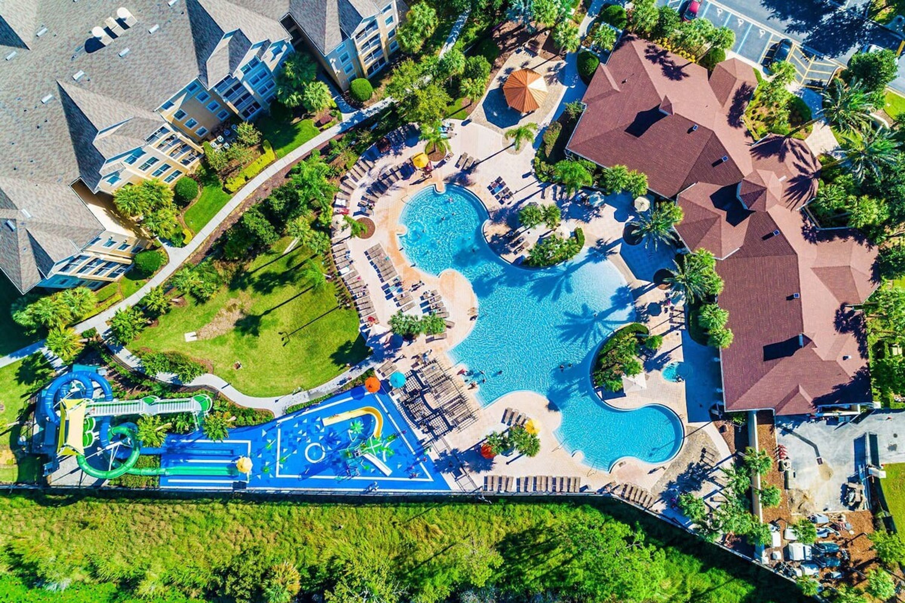 Vista aérea de un resort con varias piscinas, parque acuático y diversas zonas de estar al aire libre.