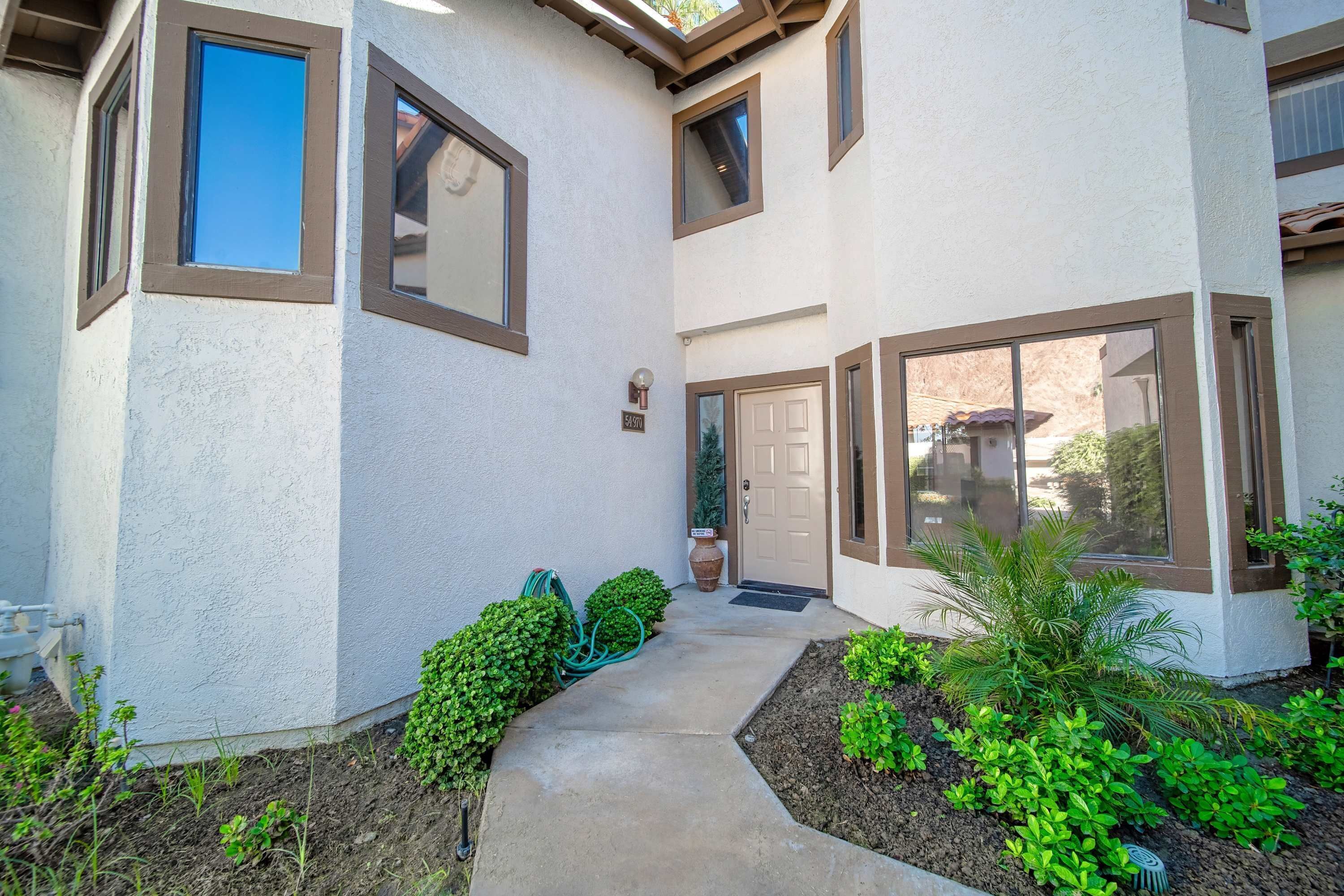 A building with a concrete pathway, a door, and a window.
