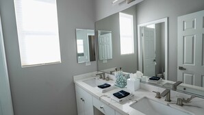 A bathroom with two sinks, a large mirror, and a window. - Palm Luxe Estate Luxury Desert Retreat With Pool (Indio)