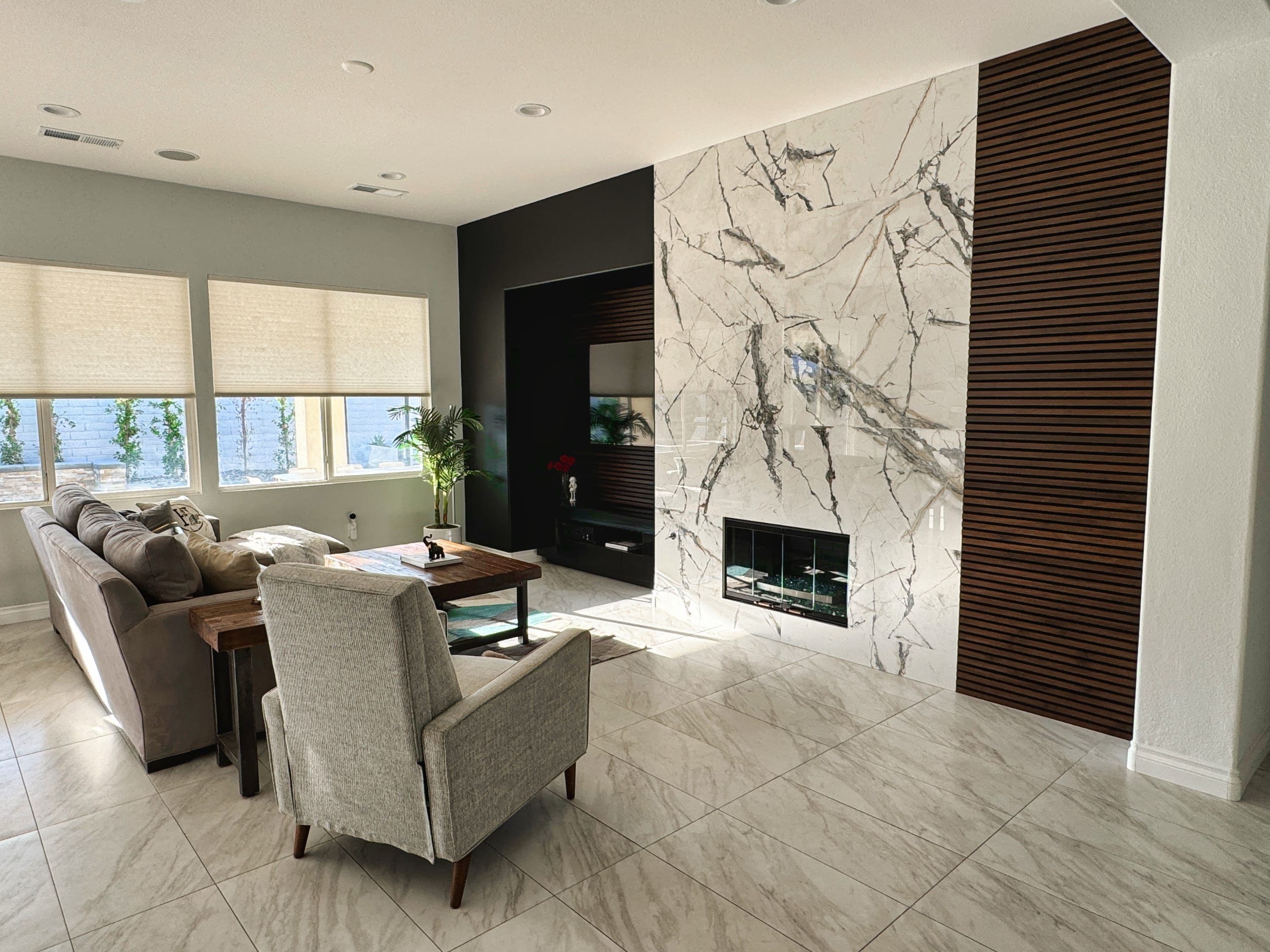 A modern living room with a sofa, armchair, coffee table, and fireplace.