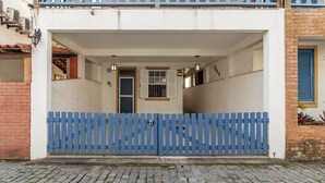 Un edificio con una verja azul, un cartel con el número 27 y una fachada blanca.