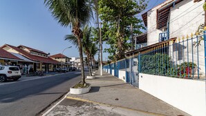 Una calle con edificios, aceras y una cerca azul.