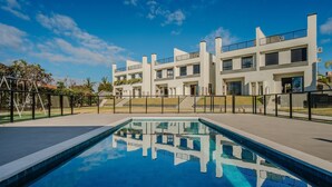 Un bâtiment moderne avec une piscine devant.