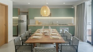 Un comedor moderno con una mesa de madera dispuesta para seis personas, rodeada de sillas de mimbre.