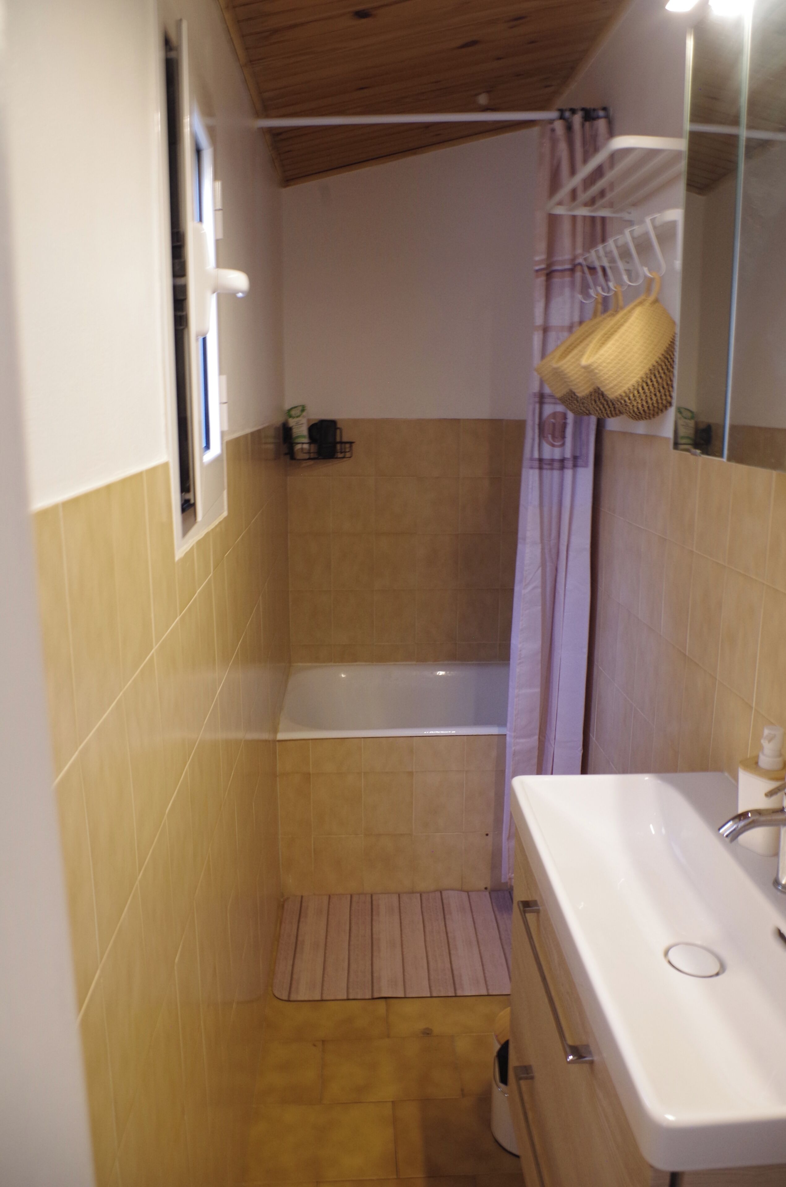 A bathroom with a bathtub, a sink, and a shower curtain.