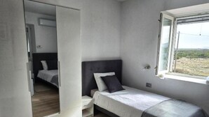 A compact bedroom with a single bed, a wardrobe, and a window with a view. - Rooms Burnum - Single Room 6 (Vrbnik-Knin)