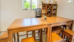 A wooden dining table with benches, a bookshelf, and a window with a view of greenery. - Rooms Burnum - Twin Room 7 (Vrbnik-Knin)