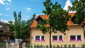 Ein zweistöckiges Gebäude mit roten Ziegeln, weißen Fensterrahmen und einer beige farbenen Fassade.