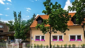 A two-story building with a red-tiled roof, white window frames, and a beige facade. - Rooms Lidija 17 - Triple Room (2) (Zagreb)