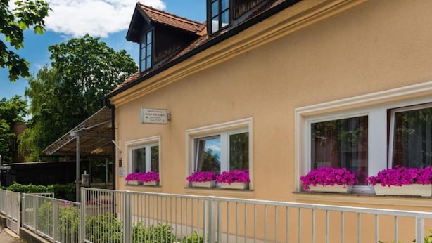 A building with a beige facade, multiple windows with flower boxes, and a white metal fence. - Rooms Lidija 17 - Triple Room (2) (Zagreb)