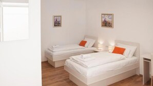 A hotel room with two single beds, a small bedside table, and a nightstand. - Rooms Lidija 17 - Twin Room (6) (Zagreb)