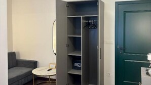 A room with a grey sofa, a small round table, a grey wardrobe, and a green door. - Rooms Lidija 32 - Double Deluxe Room (11) (Zagreb)