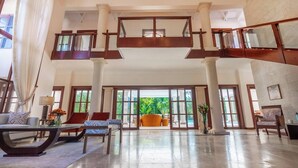 A spacious lobby with a high ceiling, large windows, and a central seating area with multiple chairs and a sofa.
